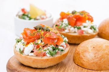 sandwich with cottage cheese, tomato and salmon on wooden board