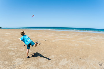 Boy Throwing Boomerang Beach Blue - obrazy, fototapety, plakaty