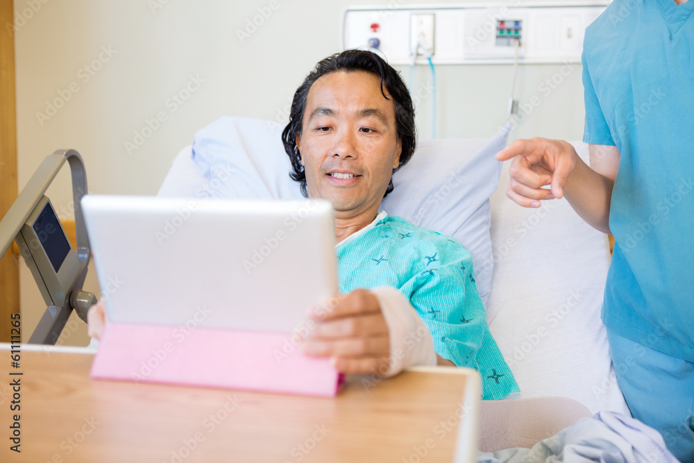 Wall mural Nurse Pointing At Digital Tablet While Patient Using It