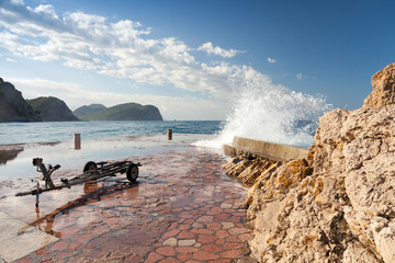 Stone breakwater with big waves. Petrovac, Montenegro