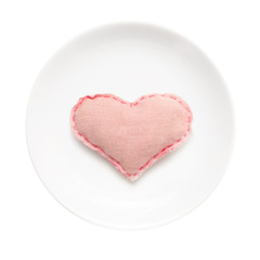 White plate with handmade heart on it isolated on white