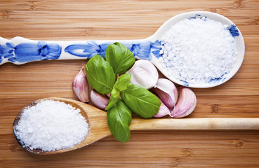 Fresh garlic on wooden table with salt on spoon