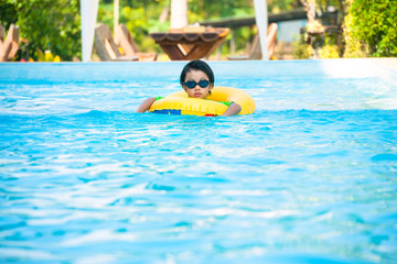 Asian boy in tube learning to swim