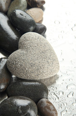 Grey stone in shape of heart, on light background