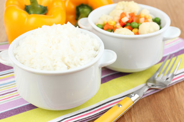 Cooked rice with vegetables on wooden table close up