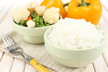 Cooked rice with vegetables on wooden table close up