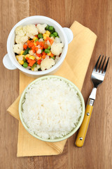 Cooked rice with vegetables on wooden table