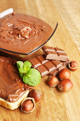 Bread with sweet chocolate hazelnut spread on wooden background