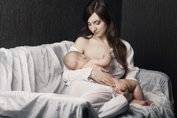 Mother breast feeding her infant studio shot