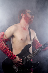 guitarist with electric guitar black, wearing face paint and red