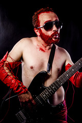 Fototapeta premium Fun, guitarist with electric guitar black, wearing face paint an
