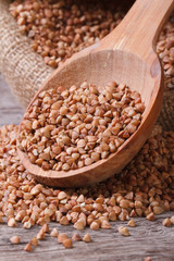 Fototapeta premium buckwheat groats macro in a bag with a wooden spoon