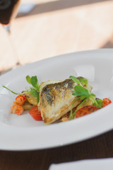 Close image of fish on dish with shrimps in restaurant