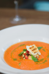 Image of tasty pumpkin soup with crouton and basil served in res