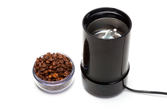 Cup with coffee beans electric grinder isolated