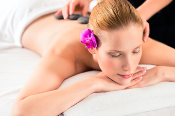 Obraz na płótnie Canvas Frau bei Hot Stone Massage im Wellness Spa