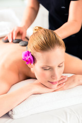 Obraz na płótnie Canvas Frau bei Hot Stone Massage im Wellness Spa