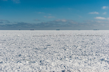 Fototapeta na wymiar frozen sea and the ships on horizon