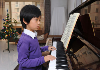 Young Asian boy learning piano