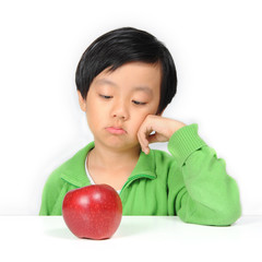 Young Asian boy reluctant to eat healthy food ( red apple )