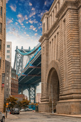 Obraz premium The Manhattan Bridge between buildings, Brooklyn. Street view at