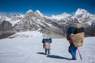 Porter carrying heavy loads in Himalayas of Nepal - obrazy, fototapety, plakaty