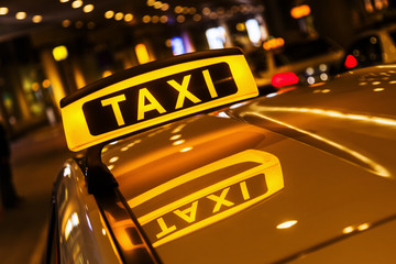 Taxischild mit Spiegelung im Dach des Taxis