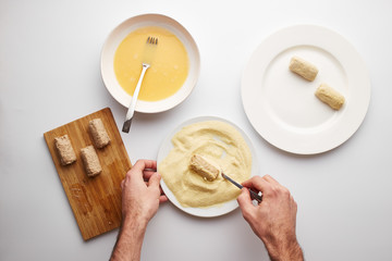 Cook's hands preparing croquettes