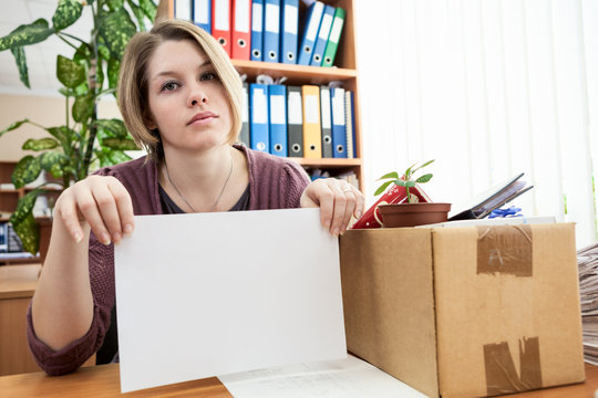 Woman, laid off at work, holding white paper in her hands