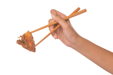 Female hand using chopstick to hold a piece of fried chicken