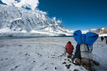 Porter with Tilicho peak and Tilicho lake in Himalayas of Nepal