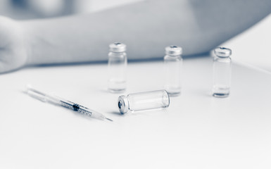 syringe and glass bottles with medicines lying on table