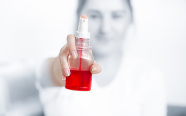 Closeup shot of woman holding bottle with red throat spray