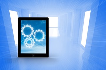 Composite image of cogs in clouds on tablet screen
