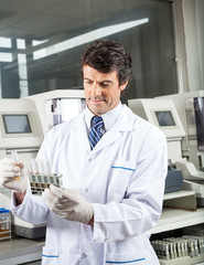 Technician Analyzing Urine Samples In Laboratory