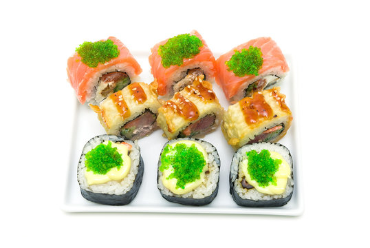 different Japanese rolls on a plate isolated on white background