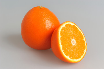 A half and whole orange on grey isolated