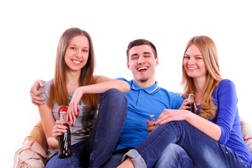 happy friends sitting on a sofa and drinking Coca Cola isolated