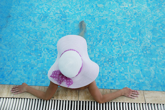 girl in a hat in the water pool