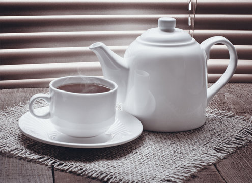 Tea Cup With Teapot On Old Wooden Table