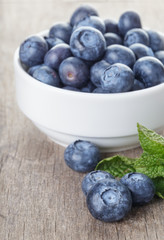 fresh blueberries in white bowl on wood table
