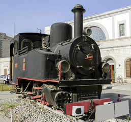 Vintage steam train alongside platform at railway station