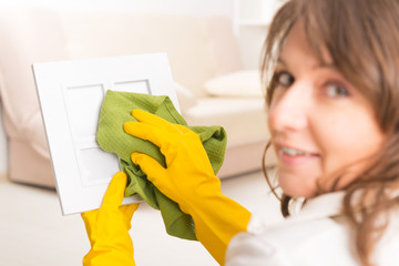Beautiful young woman cleaning frame