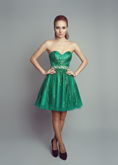 Pretty woman in luxury green dress wearing high heels