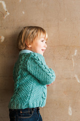 Portrait of a cute toddler boy in a knitted pullover