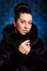 Beautiful Woman in black Fur Coat on the blue