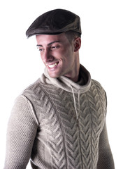 Handsome young man smiling, wearing knitted wool sweater and hat