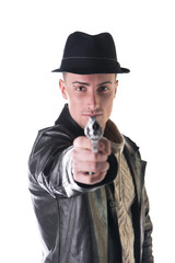 Young man pointing gun at camera, wearing hat and leather jacket