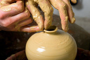 hands of a potter, creating an earthen jar