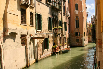 Fototapeta na wymiar Green Canal in Venice Italy under clear sky